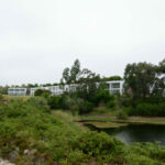 Nuno Graça Moura’s 24 Row Houses at Bom Sucesso Resort showcasing modern row house design with clean lines, integrated shrubland landscaping, and views of surrounding wetlands.