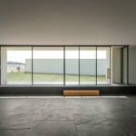 Nuno Graça Moura’s 8 Villas at Bom Sucesso Resort showcasing modern design with grey composite tile flooring, concrete ceiling, and ample daylighting.