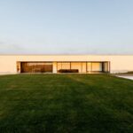 Nuno Graça Moura’s 8 Villas at Bom Sucesso Resort showcasing modern landscaping with manicured lawns, clean architectural lines, and dynamic shadow play on the villa façades.