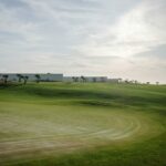 Nuno Graça Moura’s 8 Villas at Bom Sucesso Resort showcasing modern villas with clean lines, large glass façades, and landscaped grassy surroundings.
