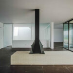 Nuno Graça Moura’s 8 Villas at Bom Sucesso Resort showcasing modern architecture with composite material flooring, steel structural elements, expansive glass panels for daylighting, and a clean, minimalist ceiling design.