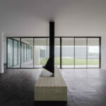 Nuno Graça Moura’s 8 Villas at Bom Sucesso Resort showcasing composite material flooring, grey ceiling elements, and large glass panels allowing ample daylighting.