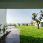 Nuno Graça Moura’s 8 Villas at Bom Sucesso Resort showcasing modern architecture with landscaped gardens, expansive lawns, and integrated green outdoor spaces surrounding the villas.
