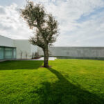 Nuno Graça Moura’s 8 Villas at Bom Sucesso Resort showcasing modern composite material structures with landscaped gardens, artificial turf lawns, and expansive green meadows under daytime lighting.