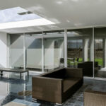 Nuno Graça Moura’s Bar Code 1 - 30 Row Houses at Bom Sucesso Resort showcasing modern interior design with silver flooring, glass elements, and a sleek ceiling structure.
