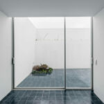 Nuno Graça Moura’s Bar Code 1 - 30 Row Houses at Bom Sucesso Resort showcasing grey tile flooring, glass sliding doors, and abundant daylighting in a modern residential design.