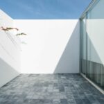 Nuno Graça Moura’s Bar Code 1 - 30 Row Houses at Bom Sucesso Resort showcasing a modern composite material façade with grey aluminium elements, tiled surfaces, and ample daylighting.