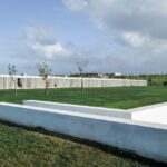 Nuno Graça Moura’s Bar Code 2 - 12 Row Houses at Bom Sucesso Resort showcasing a modern row house design with clean lines, plain façades, and landscaped lawns featuring artificial turf.