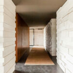 Nuno Graça Moura’s Golf Clubhouse at Bom Sucesso Resort showcasing a natural wood interior with hardwood plank flooring, composite wood ceiling, and exposed brick elements.