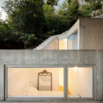 Álvaro Leite Siza Vieira Jr’s Casa Tóló showcasing a concrete and composite material structure with natural daylighting, stairs, and indoor houseplants.