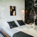 Antonio Corte-Real’s Maison de Vacances Esposende showcasing a modern bedroom with minimalist bedding, natural shade filtering through large windows, and clean architectural lines.