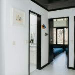 Antonio Corte-Real’s Maison de Vacances Esposende interior showcasing minimalist design with clean walls, wooden flooring, modern furniture, recessed ceiling lighting, and large doors enhancing natural light.