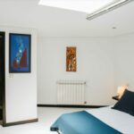 Antonio Corte-Real’s Maison de Vacances Esposende interior showcasing modern furniture, textured textiles, wooden flooring, minimalist lighting fixtures, and clean wall and ceiling designs.