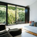 Antonio Corte-Real’s Maison de Vacances Esposende interior showcasing modern wood furniture, a comfortable couch, wooden flooring, ambient lighting, and a cozy living room design.