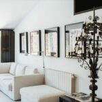 Antonio Corte-Real’s Maison de Vacances Esposende interior showcasing modern furniture, a spacious living room with a sleek couch, wooden flooring, minimalist wall design, and contemporary ceiling light fixtures.