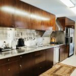 Antonio Corte-Real’s Maison de Vacances Esposende interior showcasing a modern kitchen with wood cabinetry, sleek countertops, integrated major appliances, and polished flooring.