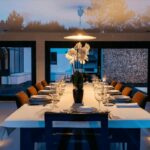 Antonio Corte-Real’s Maison de Vacances Esposende interior showcasing modern furniture, a wooden dining table with chairs, distinctive ceiling light fixtures, and sleek flooring in a bright, open room.