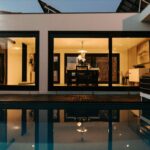 Antonio Corte-Real’s Maison de Vacances Esposende showcasing a modern home with composite material flooring, a shaded outdoor area, a swimming pool, and a sleek door integrated into the estate’s contemporary architecture.