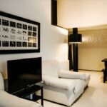 Antonio Corte-Real’s Maison de Vacances Esposende interior showcasing modern furniture, minimalist living room with sleek couch, wooden flooring, textured walls, and ambient ceiling lighting.