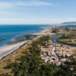 Antonio Corte-Real’s Maison de Vacances Esposende showcasing a modern coastal retreat with large glass façades overlooking the ocean, featuring clean lines and integration with the beach shoreline.