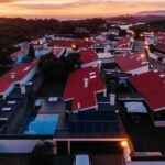 Antonio Corte-Real’s Maison de Vacances Esposende showcasing a modern residential design with a flat roof and large windows set in a suburban area at dusk.