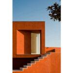 Atelier dos Remédios, Madalena Cardoso de Menezes, and Francisco Teixeira Bastos’ 10 Casa O Villas at Bom Sucesso Resort showcasing vibrant red and orange exterior design elements with modern geometric forms.