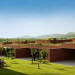Atelier dos Remédios, Madalena Cardoso de Menezes and Francisco Teixeira Bastos’ 18 Red Row Houses at Bom Sucesso Resort featuring eco-friendly landscaping, a garden courtyard, and modern red façades integrated with natural surroundings.
