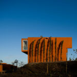 Atelier dos Remédios, Madalena Cardoso de Menezes and Francisco Teixeira Bastos’ 18 Red Row Houses at Bom Sucesso Resort featuring vibrant orange façades and modern linear assemblies.