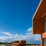 Atelier dos Remédios, Madalena Cardoso de Menezes, and Francisco Teixeira Bastos’ 18 Red Row Houses at Bom Sucesso Resort featuring composite material construction, engineered structural elements, and extensive daylighting through large windows.