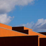 Atelier dos Remédios, Madalena Cardoso de Menezes, and Francisco Teixeira Bastos’ 18 Red Row Houses at Bom Sucesso Resort featuring orange composite material façades with dynamic daylighting and shadow patterns.