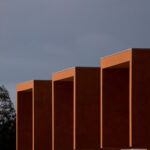 Atelier dos Remédios, Madalena Cardoso de Menezes, and Francisco Teixeira Bastos’ design of the 18 Red Row Houses at Bom Sucesso Resort featuring composite material cladding with a rich wood stain finish.