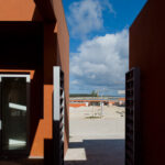 Atelier dos Remédios, Madalena Cardoso de Menezes, and Francisco Teixeira Bastos’ 18 Red Row Houses at Bom Sucesso Resort featuring brown and orange composite materials, concrete structural elements, and engineered shading designed for optimal daylighting.