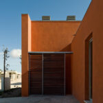 Atelier dos Remédios, Madalena Cardoso de Menezes, and Francisco Teixeira Bastos’ design of the 18 Red Row Houses at Bom Sucesso Resort showcasing concrete and plaster walls with composite materials, daylighting effects, and distinct shadow patterns.