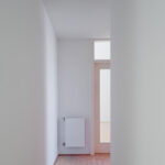 Atelier dos Remédios, Madalena Cardoso de Menezes, and Francisco Teixeira Bastos’ 18 Red Row Houses at Bom Sucesso Resort featuring wood flooring, hardwood elements, tiled flooring, and wood-stained walls and ceilings in a modern residential interior.