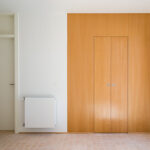 Atelier dos Remédios, Madalena Cardoso de Menezes, and Francisco Teixeira Bastos’ 18 Red Row Houses at Bom Sucesso Resort showcasing interior wood flooring, wooden doors, and warm wood-stained walls in a modern residential design.