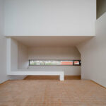 Atelier dos Remédios, Madalena Cardoso de Menezes, and Francisco Teixeira Bastos’ design of the 18 Red Row Houses at Bom Sucesso Resort showcasing wood flooring, hardwood stairs, wood-stained ceiling, and abundant daylighting.