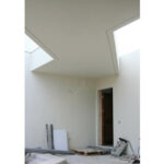Atelier dos Remédios, Madalena Cardoso de Menezes and Francisco Teixeira Bastos’ 5 Casa K /360 Villas at Bom Sucesso Resort showcasing an interior design with plaster ceilings, triangular light fixtures, and abundant daylighting.