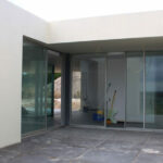 Atelier dos Remédios, Madalena Cardoso de Menezes, and Francisco Teixeira Bastos’ 5 Casa K /360 Villas at Bom Sucesso Resort featuring a modern composite and concrete structure with large glass doors, shaded daylighting, and sleek flooring.