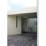 Atelier dos Remédios, Madalena Cardoso de Menezes and Francisco Teixeira Bastos’ 5 Casa K /360 Villas at Bom Sucesso Resort featuring concrete floors, shaded areas, daylighting, and a modern home door.