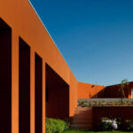 Atelier dos Remédios, Madalena Cardoso de Menezes, and Francisco Teixeira Bastos’ 6 Casa I Villas at Bom Sucesso Resort featuring modern villas with orange accents, clean lines, and large glass façades.