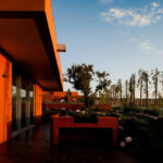 Atelier dos Remédios, Madalena Cardoso de Menezes, and Francisco Teixeira Bastos’ 6 Casa I Villas at Bom Sucesso Resort featuring wooden stained façades with orange shading under evening dusk light.