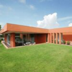Atelier dos Remédios, Madalena Cardoso de Menezes, and Francisco Teixeira Bastos’ design of the 6 Casa I Villas at Bom Sucesso Resort showcasing modern homes with landscaped gardens, artificial turf lawns, shaded yards, and spacious courtyards.