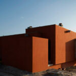 Atelier dos Remédios, Madalena Cardoso de Menezes, and Francisco Teixeira Bastos’ 6 Casa L Villas at Bom Sucesso Resort featuring orange composite material façades with daylighting effects and sharp shadow contrasts.