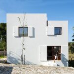 Guilherme Machado Vaz’s House in Afife showcasing a plastered wall exterior within a residential area on a land lot.