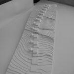 Josep Llinás’s House Model 2 showcasing a minimalist design with silver accents, sharp shadows, and paper-like textured surfaces.