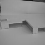 Josep Llinás’s House Model 2 showcasing a modern interior with wood flooring, plywood desk, and composite material elements emphasizing minimalist design.
