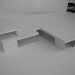 Josep Llinás’s House Model 2 showcasing a modern interior with plywood composite flooring, a hardwood writing desk, and minimalist furniture arrangements.