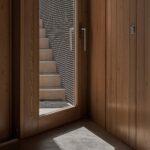 Manuel Aires Mateus’s Casa Na Terra showcasing a minimalist design with prominent brown hardwood flooring composed of wide wooden planks and natural wood stain.
