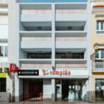 Manuel Gomes da Costa’s Modernist Faro showcasing a mixed-use commercial and apartment building with balconies and a sleek glass façade.