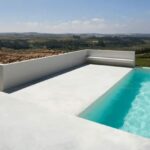 Ricardo Bak Gordon’s Casa em Sobral da Lagoa showcasing a modern design with a swimming pool, composite material cladding, and tiled surfaces.